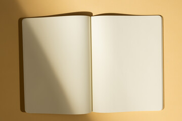 Open blank notebook on a beige surface, with copy space