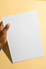 Biracial man holding a blank white paper, with copy space