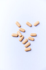 Ashwagandha (Withania somnifera) tablets on paper background. Soft focus. Close up. Copy space.	
