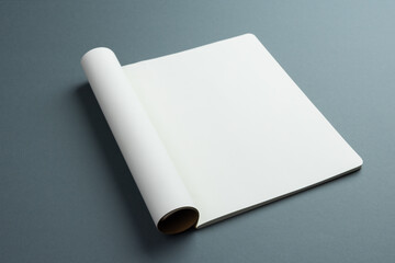 An open blank notebook lies on a gray surface, with copy space