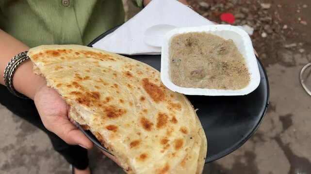 Lachha paratha served with mutton rezala at a roadside stall in India