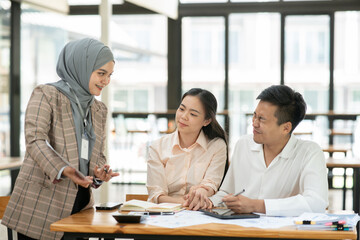 Group of business people meeting and present work on the board.