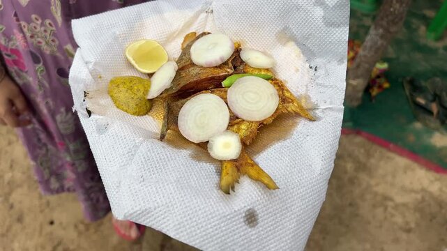 Fried white pomfret served in the beach of Digha, Bengal with onion and lime