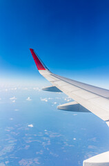 View from the airplane window at a beautiful cloudy sky and the airplane wing