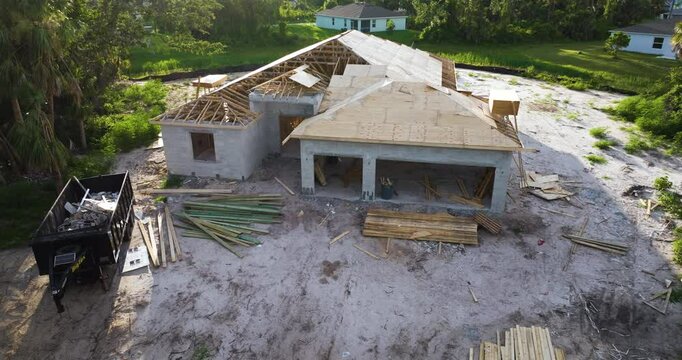House under construction with roof assembling work. Residential private home with wooden roofing structure in Florida rural area. Real estate development concept