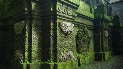 Old Built Structure With Mossy Carvings In Alas Harum Bali In Tegallalang, Indonesia. Jungle Temple. closeup, arc shot