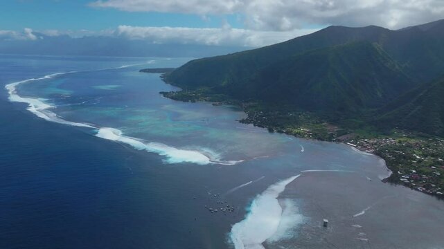 Coastal Teahupoo Tahiti aerial drone view French Polynesia coral reef surf break waves Pacific Ocean channel boats cloudy sunny  judge tower surfing contest Point Faremahora Pass Havae backward pan up