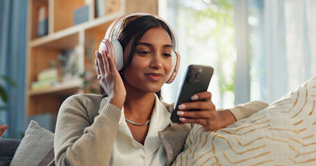 Headphones, indian woman and cellphone for music in home, listen and song in living room. Joyful,...