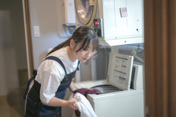 洗濯ものを回す女性