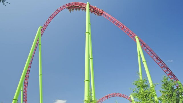 Roller coaster Ride against blue sky. Roller coaster in the amusement park. Cheerful entertainments in park of attractions