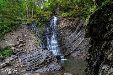 Mountain waterfall in summer. Travel landscape of Zhenetsky Huk waterfall, Ukraine