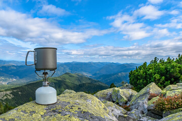 Gas burner with cauldron at mountains. Tourist camping cooking