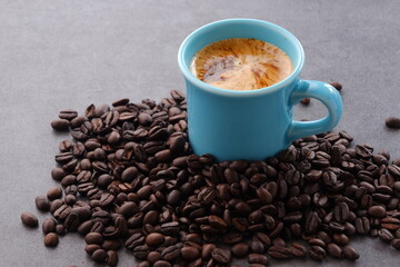 エスプレッソに牛乳をたっぷり入れたコーヒー、カフェ・ラッテと、深煎りしたコーヒー豆
