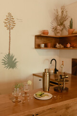 Home bar with cocktails and lime slices on a wooden counter.