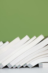 Books Leaning on Pastel Green Surface