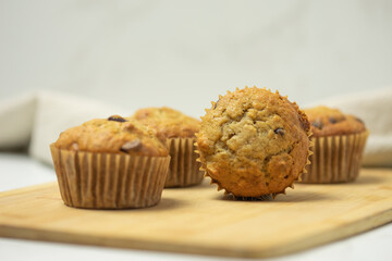 Four muffins on a cutting board with a view of the top of one muffin