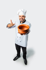 Smiling Asian Indian chef or professional cook with terracotta pot, plate or bowl, High angle top view.