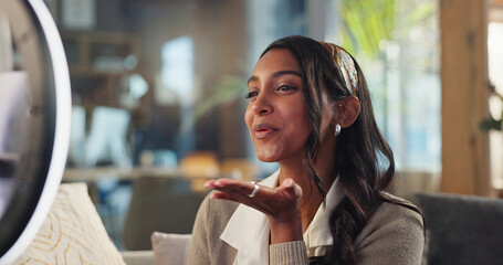 Kiss, smile and woman on couch for live stream, content creation or online platform in home. Streamer, influencer or girl on sofa with intro on mobile app to like, subscribe or follow on social media