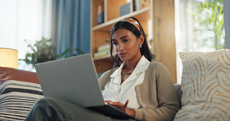 Businesswoman, laptop and blog on couch for reading, email and digital report in home. Remote work,...