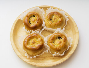 Close-up and top angle view of four Gyeongju breads on wrapping paper and wood dish, South Korea
