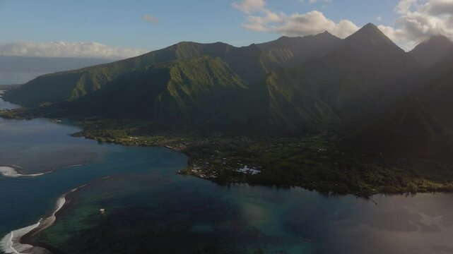 Golden sunrise Teahupoo Tahiti  aerial drone French Polynesia sun glare clouds South Pacific towering mountainscoast sunrise judge tower surf wave reef channel WSL surfing Olympic venue circle left