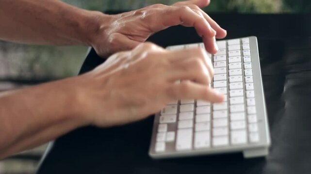 Man typing with a mini white computer keyboard. 4K Resolution..mp4