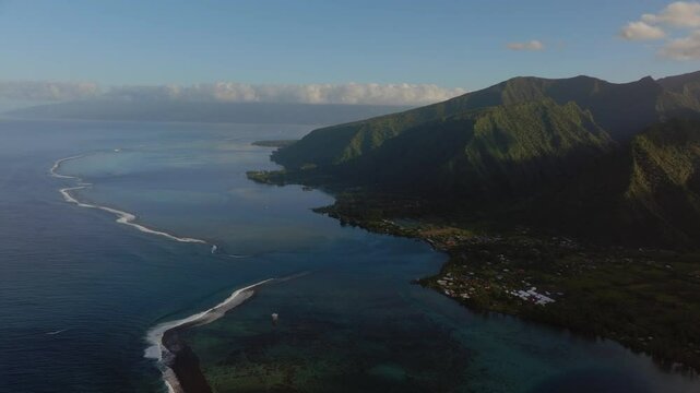 Morning sunrise volcano island mountains Teahupoo Tahiti aerial drone French Polynesia South Pacific surf wave reef channel WSL surfing Olympic venue up the coastline shore coral reef circle left
