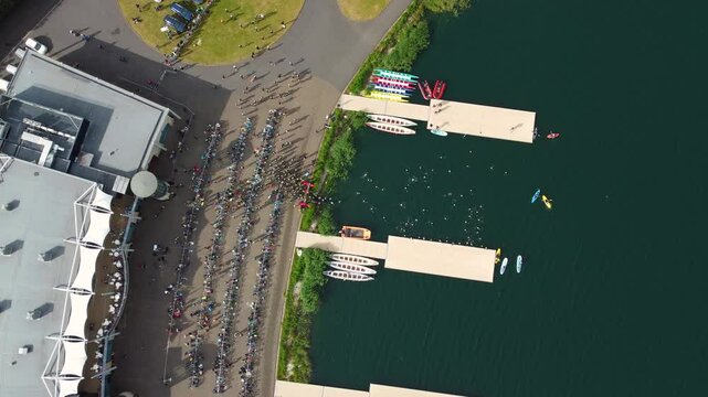 Top angle shot of Triathlon at Dorney lake, triathletes are beginning the race and swimming towards the transition area