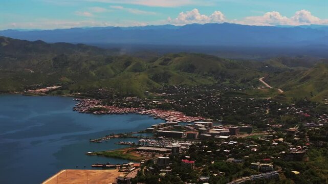 Port Moresby Harbour Marina Papua New Guinea beautiful sunny blue sky morning Ela Beach parallax aerial drone car traffic PNG Crown Hotel Plaza Hilton Walter Bay Coral Sea capital city circle left