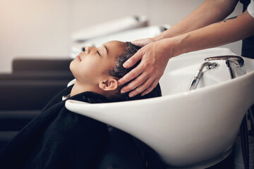 Fototapeta premium Washing, kid or hands of hairdresser with girl in salon basin for natural scalp care or cleaning treatment. Rinse, spa or beauty service for client, child or shampoo cosmetics for health or wellness