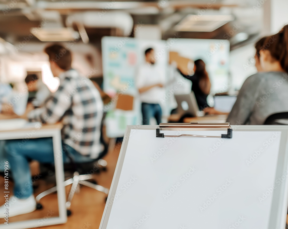 Poster a blurred office scene with people in a meeting, focus on a clipboard in the foreground on a light b