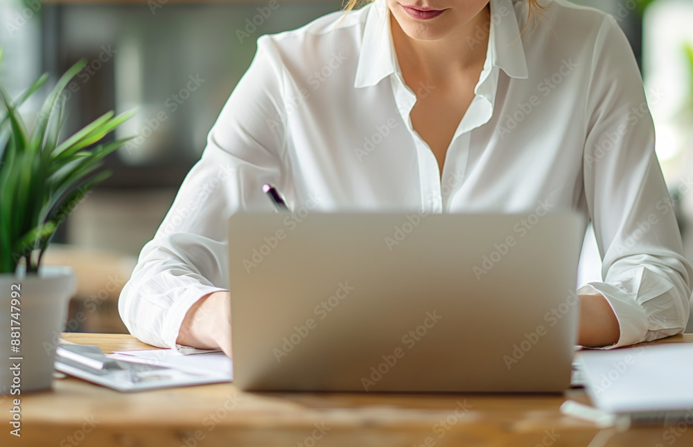 Poster close-up of a woman working on a laptop with a blurred background, symbolizing focus and productivit