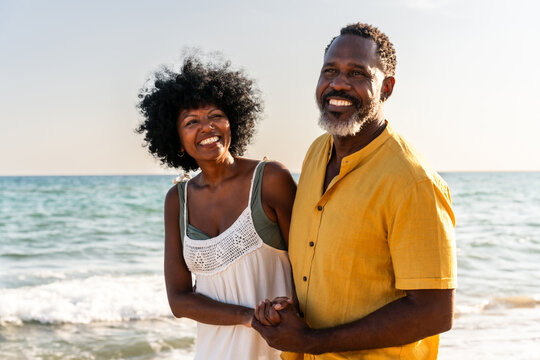 Beautiful mature senior black couple of lovers dating at the seaside - Married african middle-aged couple bonding and having fun outdoors, concepts about relationship, lifestyle and quality of life - Powered by Adobe