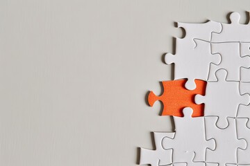 Obraz premium Jigsaw puzzle with an orange piece on a solid background, symbolizing successful job candidate the confidence. Standing out from the crowd. Copy space for text