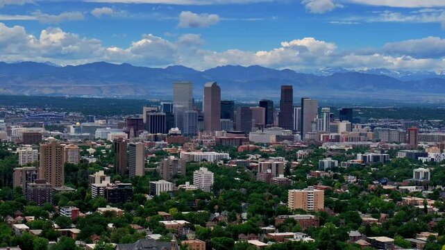 Summer in downtown Denver aerial drone front range Colorado mountain peak foothills landscape Flat irons Red Rocks city skyscrapers neighborhood homes blue skies clouds spring circle left motion