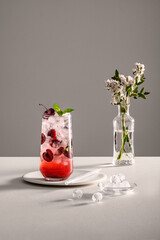 작은 둥근 얼음이 들어있는 유리잔에 체리와 시원한 탄산음료가 들어있다. 