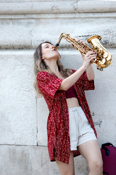 Woman playing the saxophone on a city street