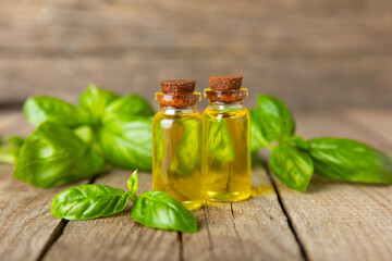 Basil essential oil on a textured wooden background. Basil essential oil and fresh leaves. Aromatherapy. Aroma oil. Medical herbs. Alternative medicine. Place for text. Copy space.