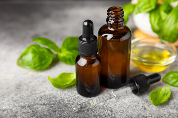 Basil essential oil on a textured wooden background. Basil essential oil and fresh leaves. Aromatherapy. Aroma oil. Medical herbs. Alternative medicine. Place for text. Copy space.