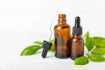 Basil essential oil on a textured wooden background. Basil essential oil and fresh leaves. Aromatherapy. Aroma oil. Medical herbs. Alternative medicine. Place for text. Copy space.