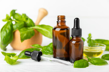 Basil essential oil on a textured wooden background. Basil essential oil and fresh leaves. Aromatherapy. Aroma oil. Medical herbs. Alternative medicine. Place for text. Copy space.