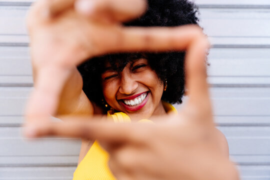 Beautiful young black woman outdoors in the city - African american female teenager with afro hairstyle portrait
