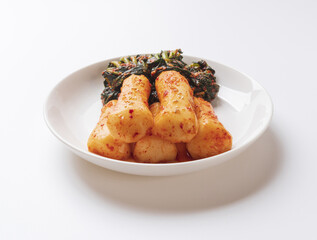 Close-up of Chong-gaggimchi(bachelor kimchi) with radish roots and leaves on dish and white floor, South Korea
