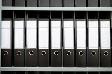 Many documents organized in row on office shelf, Folders binders. 