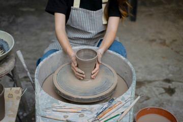 Young women is making earthenware at workshop.