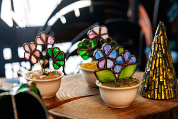Stained Glass figures in shape of flowers pot in shop-front. colorful souvenirs