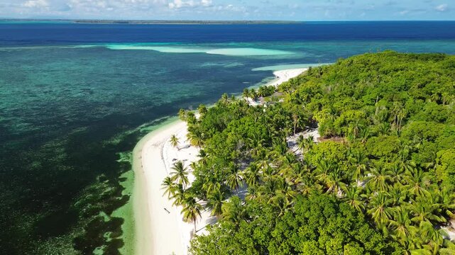 Descending aerial view of Candaraman Island in Balabac Palawan Philippines with white sand shoreline turquoise shallows and dense palm forest