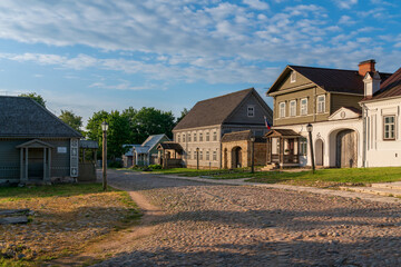 View of historical merchant buildings of estates on the main street of Izborsk Pechorskaya Street on a summer sunny day, Izborsk, Pskov region, Russia