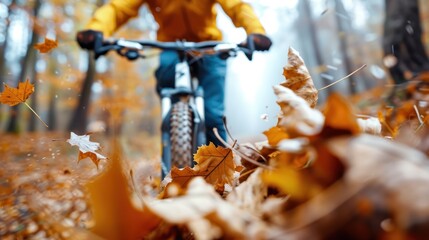 A cyclist in protective gear rides a mountain bike through a path covered in autumn leaves, capturing the essence of adventure, nature, and the joy of outdoor sports in fall.