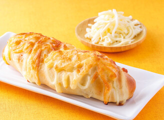 Double cheese sticks puff pastry served on wooden board isolated on orange background side view of hong kong cafe baked food dessert